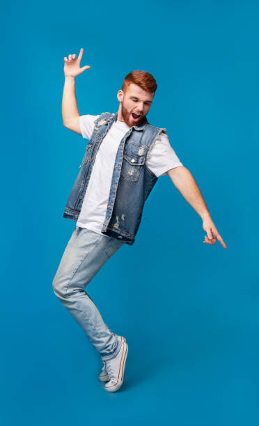istock Young cheerful man dancing on tiptoes on background 2196431643