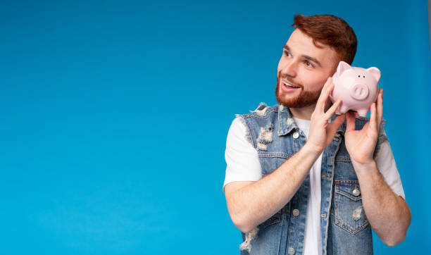 istock Dreamy millennial guy thinking about saving his money at home 2196431662