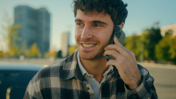 istock Smiling guy handsome 30s Caucasian man driver talk mobile phone with auto car background on parking happy male successful businessman calling smartphone friendly conversation in city urban lifestyle 2196432118