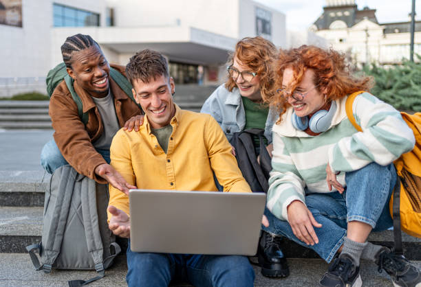 istock Group of students gathers around a laptop 2196432143