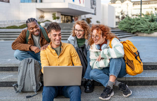 istock Group of students gathers around a laptop 2196433023