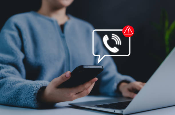 Phone scam alert notification concept. A person holding a smartphone with a digital scam warning notification, fraudulent calls, cybersecurity threats, and telecommunication security awareness. fraud, Phone scam alert notification concept. A person holding a smartphone with a digital scam warning notification, fraudulent calls, cybersecurity threats, and telecommunication security awareness. fraud, hoax stock pictures, royalty-free photos & images