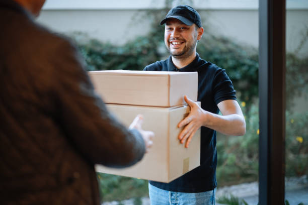 istock Close up of hands cargo staff are delivering cardboard boxes with parcels inside to the recipient's hand. 2196438325