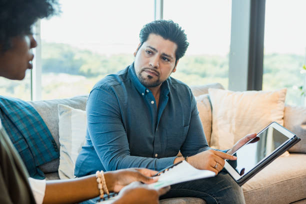 istock Man and Woman Discussing on Tablet During Counseling Session 2196439371