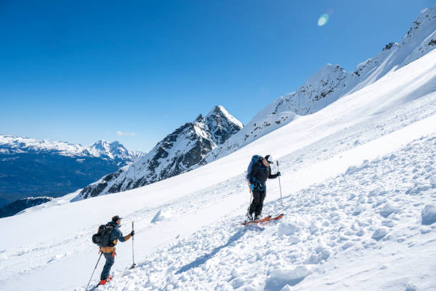 istock Backcountry skiers climb mountain 2196439523