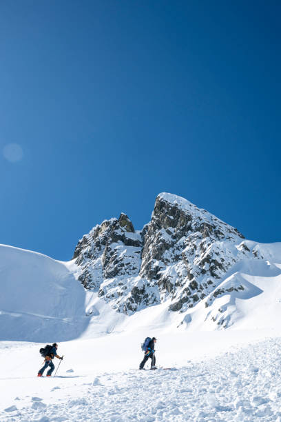 istock Backcountry skiers climb mountain 2196439524