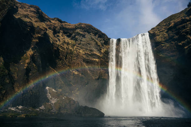 istock icelandic waterfall and a rainbow in a sunny day 2196439548