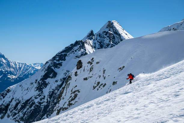 istock Backcountry skier descends mountain top 2196439577