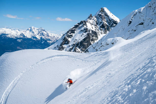 istock Backcountry skier descends mountain top 2196439683