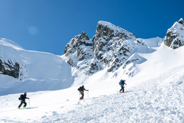 istock Group of backcountry skiers climb mountain 2196439703
