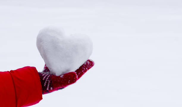istock Heart of snow on hand 2196440418