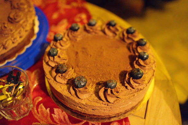 A rich and decadent chocolate cake decorated with a ring of fresh blueberries and chocolate frosting swirls. This homemade dessert is the perfect indulgence for special occasions or a cozy celebration.