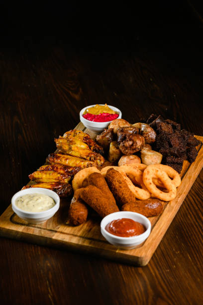 istock Assorted grilled meat appetizers on wooden board, top view. 2196445693
