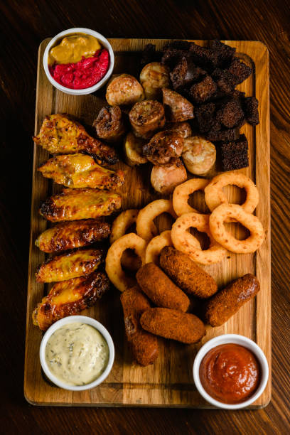 istock Assorted grilled meat appetizers on wooden board, top view. 2196445767
