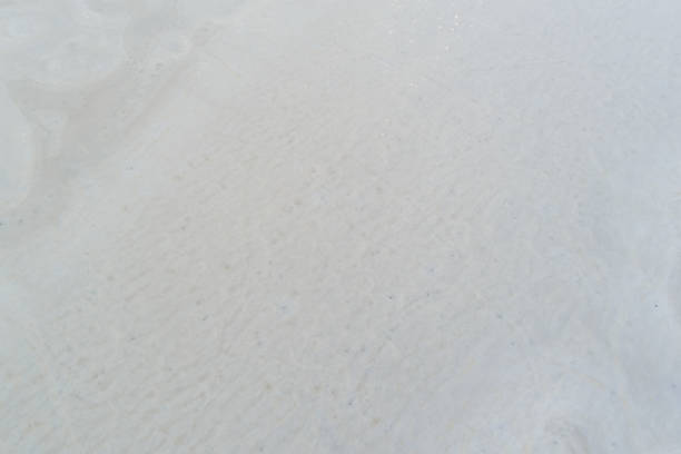 Frozen lake surface aerial view: Minimalist white background texture with subtle ice cracks and patterns, perfect for winter designs.