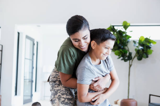 istock Happy military mom hugging son at home 2196449223