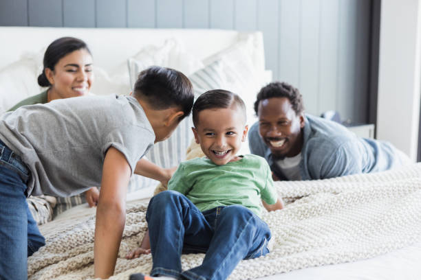 istock Happy Multiracial Family Playing on Bed Together 2196449243