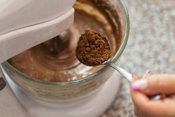 Women mixing ingredients with electric mixer to make chocolate cake or brownies
