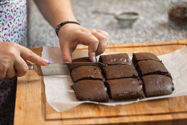Woman cutting freshly baked chocolate brownies