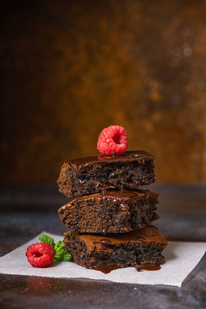 Freshly made chocolate brownies served with raspberries on the top