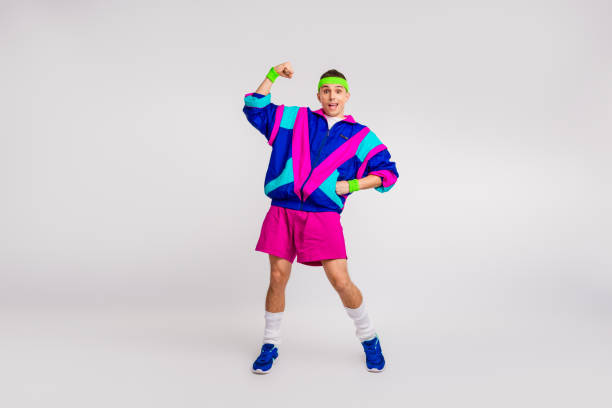 istock Energetic young man in vibrant retro sportswear posing confidently for a dynamic workout photo on a white background. 2196451323