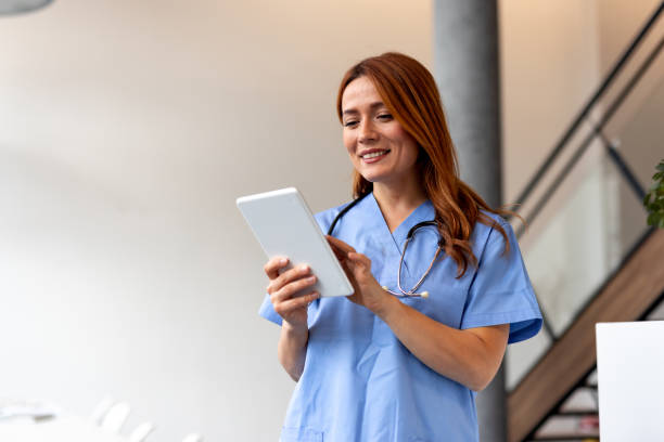 istock Smiling nurse using digital tablet in hospital 2196452869