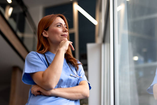 istock Confident Nurse Standing by a Window Reflecting During a Shift in a Hospital 2196453130