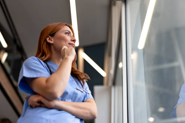 istock Health Professional Reflecting by a Window in a Modern Workplace 2196453136
