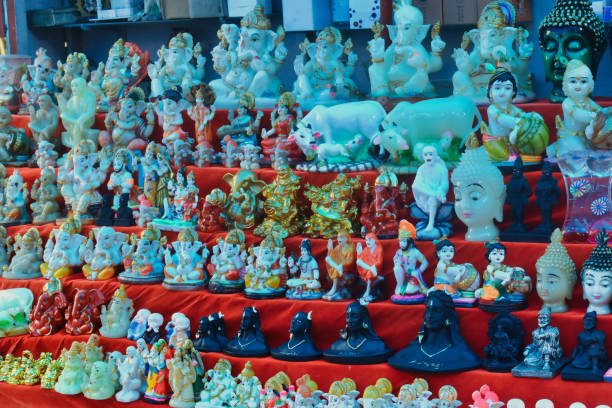 istock Various artistic figurines are arranged on vibrant red fabric at a bustling market, showcasing intricate details and craftsmanship 2196453509
