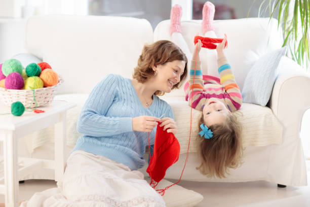 istock Mother and daughter knitting woolen scarf 2196453611