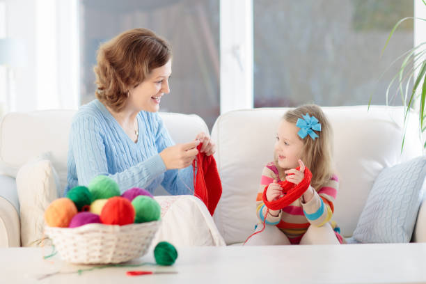 istock Mother and daughter knitting woolen scarf 2196453803