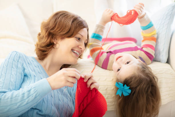 istock Mother and daughter knitting woolen scarf 2196453891