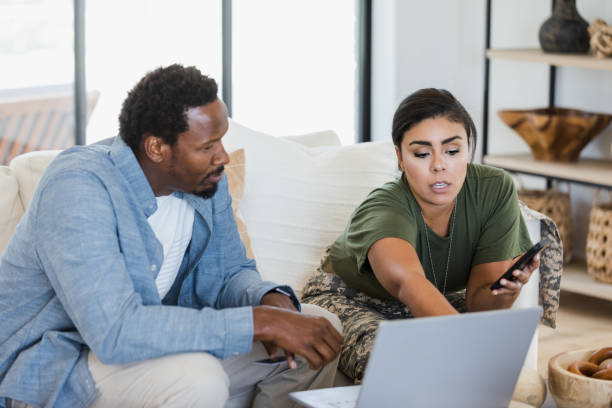istock Military Couple Using Laptop, Discussing Plans Together at Home 2196455463