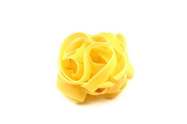 istock Raw tagliatelle pasta isolated on white background with full depth of field. Top view. Flat lay 2196463264