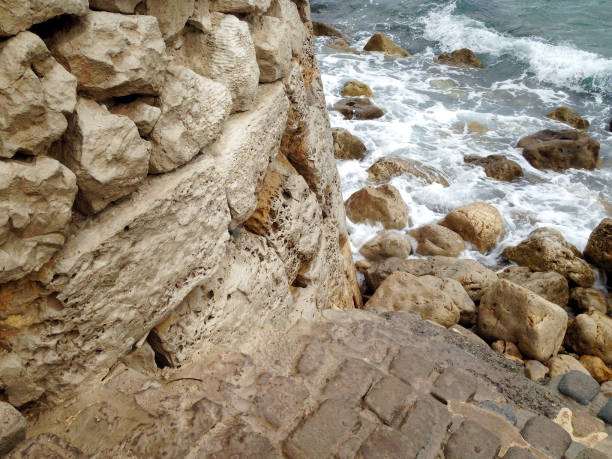 istock Coastal stone wall with textured rocks by the sea 2196464542