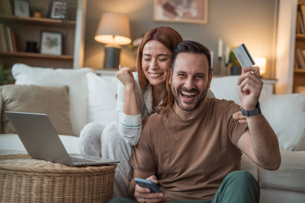 istock Couple celebrating a successful purchase after online shopping 2196465522