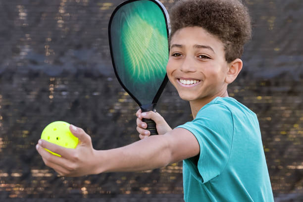 istock Young boy playing pickleball on sunny court 2196468000