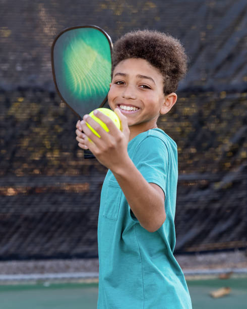 istock Young boy playing pickleball on sunny court 2196468005
