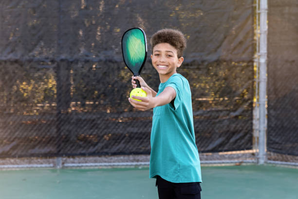 istock Young boy playing pickleball on sunny court 2196468026