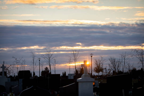 A peaceful cemetery is beautifully illuminated by a tranquil sunset, which casts warm hues and symbolizes remembrance