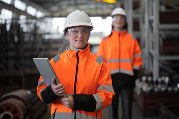 A day at work for female engineers in modern factory. Gender equality & women empowerment in the industrial sector & infrastructure. Portrait in industrial site.