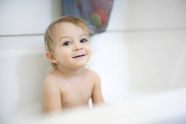 A delightful image showing a young child smiling joyfully while enjoying a bath. The simplicity and purity of the scene highlight the innocence and charm of childhood moments.