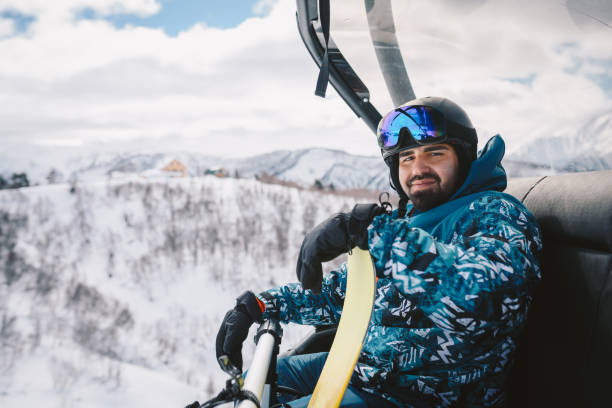 istock Man with Snowboard sitting on a Ski lift 2196472049