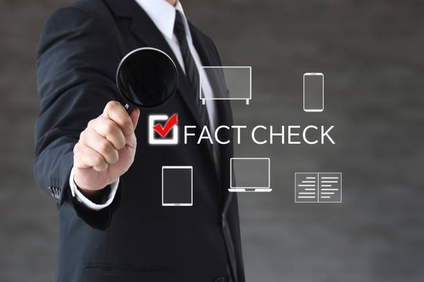 istock Businessman using magnifying glass to fact check 2196475999