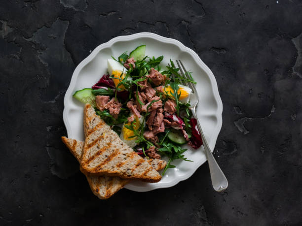 istock Salad with canned egg, boiled eggs, cucumber, arugula on a dark background, top view 2196482754