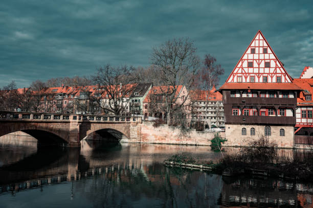 Maxbrucke bridge, Henkerhaus Museum and Weinstadel reflecting in Pegnitz river at twilight, Nuremberg, Germany