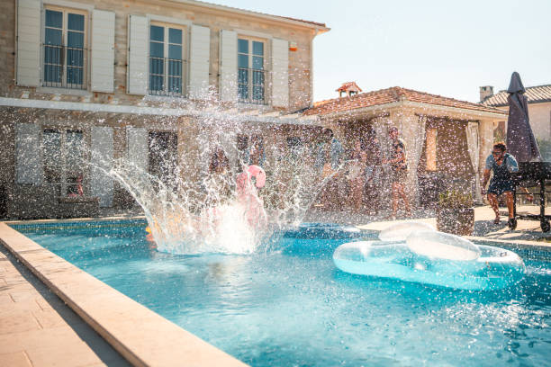 istock Diverse Friends Enjoy Cannonball Splash at Luxury Villa 2196483194
