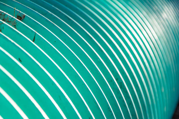 A highly detailed close-up view of a curved surface with parallel white lines against a green backdrop, evoking an abstract visual concept and a modern design element.