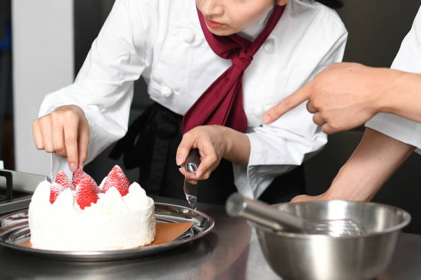 istock Male and female pastry chefs making cake in the kitchen 2196488076