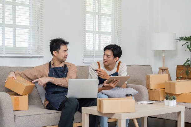 istock Two delivery professionals engaged in a lively discussion about packages while seated in a bright office space 2196488266